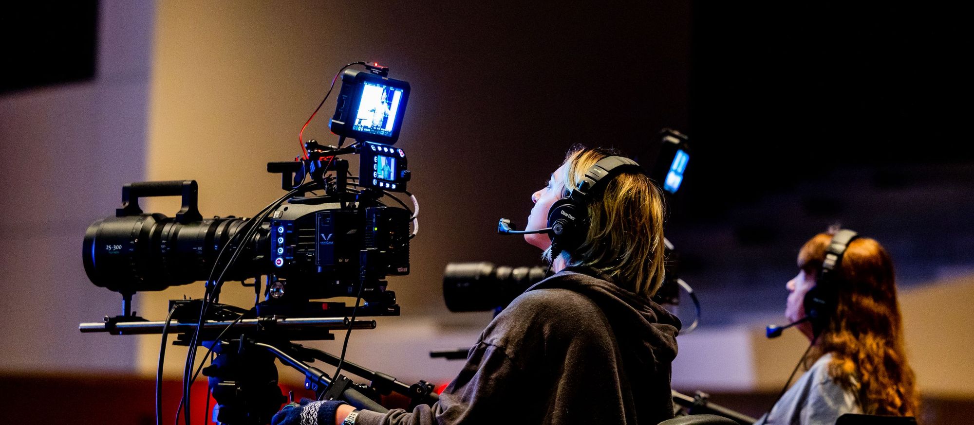 Camera operators with headsets filming on a television studio floor